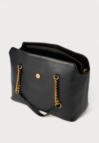 Zwarte leren tote bag met gouden kettinghandvatten, voorzien van een ritssluiting bovenaan en een zichtbare knopaccent aan de voorkant. Gladde textuur.