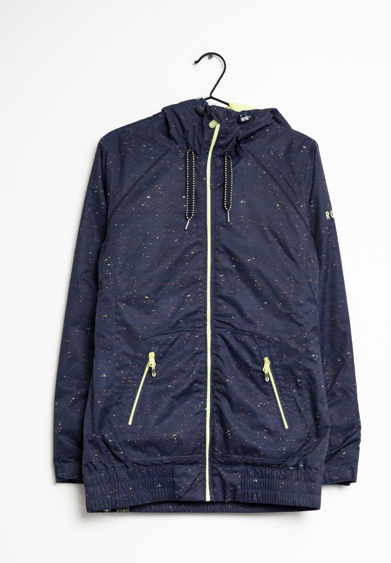 Veste à capuche bleu marine avec des taches multicolores, fermeture éclair frontale, deux poches zippées, taille élastique et capuche avec cordon, suspendue sur un cintre noir.