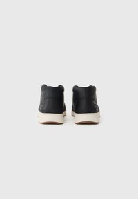 Zapatillas altas de cuero negro con un acabado texturizado, suela de goma crema y un diseño minimalista. Presenta costuras y detalles del logo.