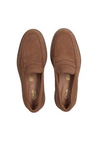 Bruine suede instappers met een moccasinontwerp, voorzien van stiksels en een gevoerd voetbed. Geen zichtbare hardware of patronen.