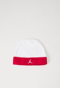 Bonnet en tricot blanc avec une bande repliée rouge arborant un logo Jumpman blanc. Texture douce et lisse avec une forme supérieure arrondie.