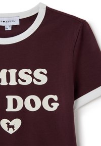 Camisa de manga corta burdeos con ribete blanco y el texto "MISS DOG" en grandes letras blancas, además de un corazón con la silueta de un perro pequeño.