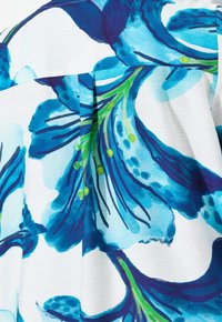 Blommönstrad klänningstyg med stora blå blommor, gröna detaljer och vit bakgrund. Har ett texturerat, lätt material och plissering.