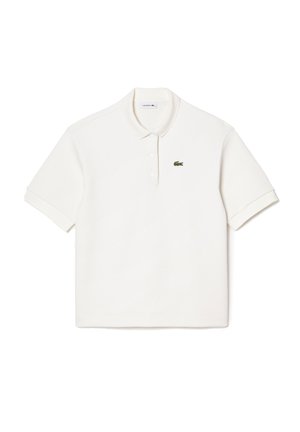 Chemise polo blanche en coton, avec un col rabattable, des manches courtes et un petit logo de crocodile brodé vert sur la poitrine gauche.