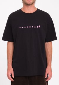Zwart t-shirt met korte mouwen, voorzien van een roze grafisch logo ontwerp op de borst, gemaakt van katoen met een losse pasvorm en ronde hals.