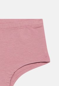 Roosa puuvillane aluspesu, millel on sile tekstuur, lihtsa disainiga ja veniv vöökoht, lähedane vaade jalgade avausele.