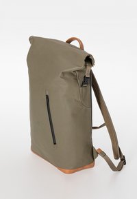 Khakifarbener Roll-Top-Rucksack mit vertikalem Reißverschlussvordertasche, braunen Lederakzenten an Griff und Boden sowie verstellbaren, gepolsterten Schultergurten.