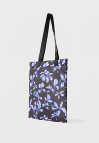 Μαύρη τσάντα ώμου με λεπτούς ιμάντες και μπλε και ροζ ανθικό σχέδιο στην υφασμάτινη επιφάνεια.