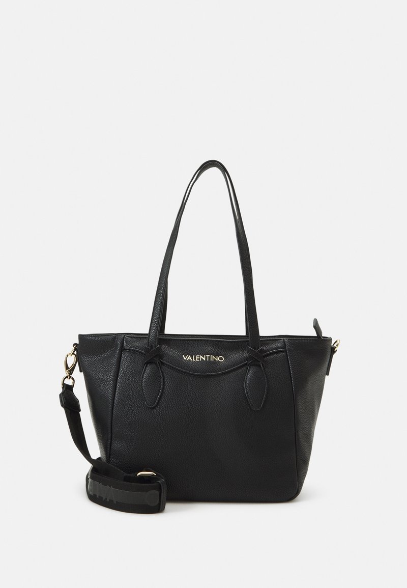 Černá kožená taška tote s jemně texturovaným povrchem, dvojitými ramenními úchyty a odnímatelným popruhem. Obsahuje zlatý akcent v podobě loga a má strukturovaný tvar.