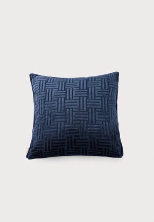 Cojín cuadrado decorativo de terciopelo azul oscuro con patrón de rayas geométricas texturizadas, sobre fondo liso claro.