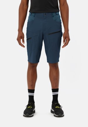 Men's blue shorts made from lightweight fabric, featuring multiple zippered pockets, a flat waistband, and contrasting teal accents.