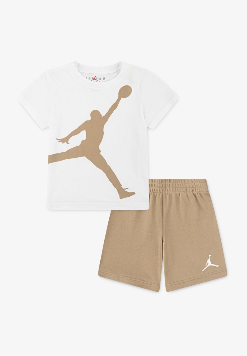 T-shirt en coton blanc avec une silhouette de basket-ball dorée, associée à un short beige arborant un logo blanc sur l'ourlet.