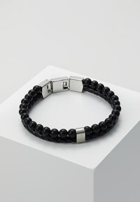 Black woven leather bracelet with spherical black beads and a silver magnetic clasp, featuring a smooth texture and subtle metallic accents.