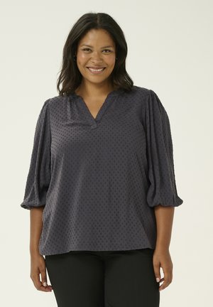 Mörkgrå blus med en strukturerad mönstring, V-ringning och trekvartslånga puffärmar. Tyget är mjukt och faller elegant.