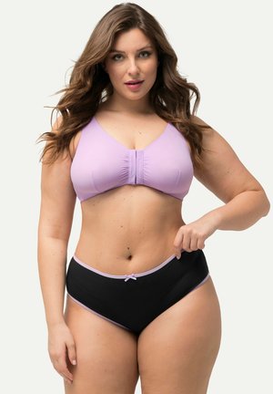 Lila sportbeha met geplooide voorkant, gecombineerd met zwarte high-waisted onderbroek met lila bies en een kleine strikaccent. 