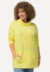 Haut à capuche jaune avec une texture douce, comportant une poche kangourou et un texte en relief "WAY OF LIFE". La capuche est dotée de cordons de serrage et de poignets côtelés.