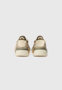 Sneaker verdi e beige con materiali in rete e suede, caratteristiche di accenti arancioni, colletto imbottito e suola in gomma testurizzata.