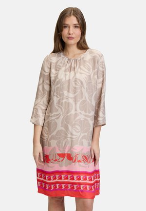 Robe beige clair avec un motif floral, col rond et manches trois-quarts. L'ourlet inférieur présente des rayures horizontales roses et rouges.