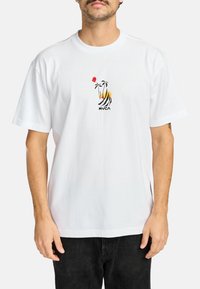 Witte katoenen t-shirt met korte mouwen, featuring een kleurrijk geborduurd ontwerp van palmbomen en een zon. Merken "RVCA" onder de grafische afbeelding.