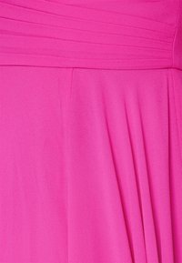 Robe fuchsia avec un design de corsage plissé et un tissu doux et texturé. La jupe a une silhouette flottante avec des drapés délicats.