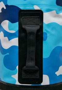 Blå og hvid camouflagemønsteret taske lavet af holdbart materiale, der har et sort håndtag og en sort forstærket kant.