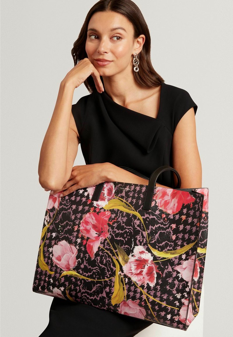 Grande borsa tote nera con motivi floreali e design pied de poule. Materiale resistente, con manici in pelle nera e vivaci fiori rosa.