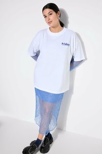 Bílé oversized tričko s potiskem "Pátek", vrstvené přes modrou krajkovou midi sukni. Černé platformové boty se stříbrnými hroty.