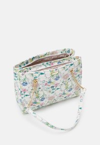 Hvid blomsterquiltet håndtaske med guldkæderem og en åben top, der viser et mønstret indvendigt foer.