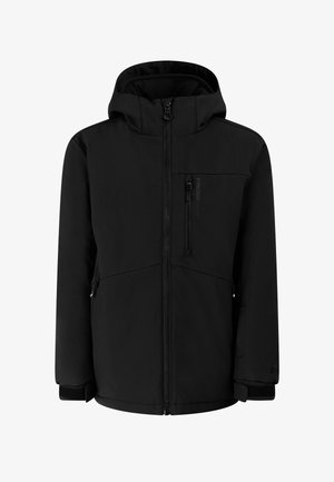 Jong persoon draagt een zwarte winterjas, beige skibroek, zwarte sneeuwlaarzen, beige muts en zwarte skibril op het voorhoofd.