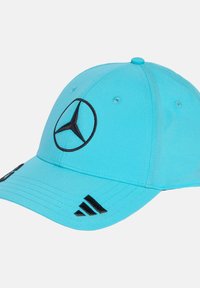 Turkis kasket i blødt stof med sort broderet Mercedes-logo og tre sorte striber på skyggen. Justerbar lukning bagpå.
