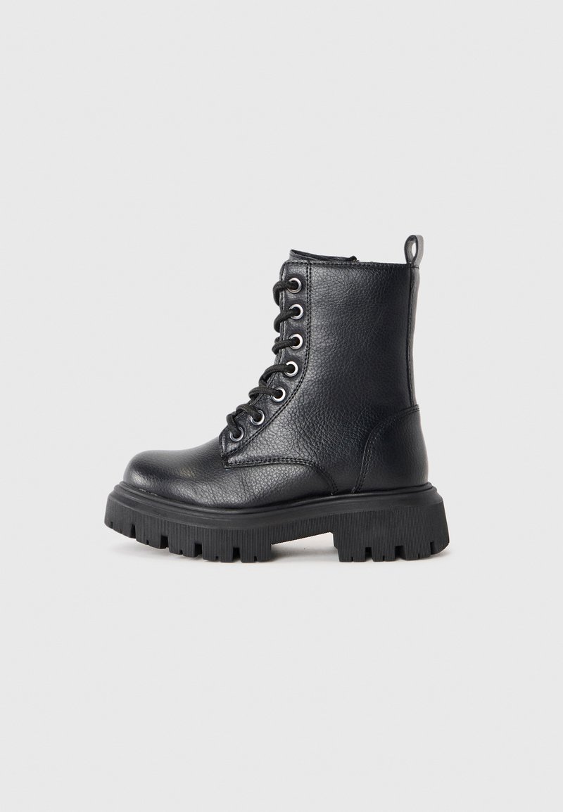 Bota de combate de cuero negro con un acabado texturizado, parte delantera con cordones y suela resistente. Presenta una lengüeta en la parte posterior para facilitar su uso.
