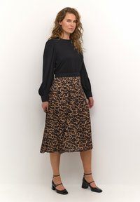 Crna bluza dugih rukava s naboranom teksturom, uparen s midi smešanim leopard uzorkom. Nositi s crnim cipelama na blok petu.