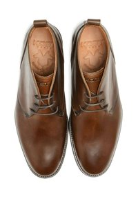 Chaussures en cuir marron avec une finition lisse, design à lacets, bout arrondi et logo en relief sur la semelle intérieure. Silhouette classique et épurée.