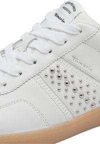 Baskets blanches en cuir synthétique avec des clous ronds argentés, des accents texturés et des lacets traditionnels ; dotées d'une semelle en caoutchouc.