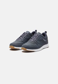 Gray athletic shoes with a smooth upper, perforated details, and a white midsole. Rubber outsole features a gum-colored finish.