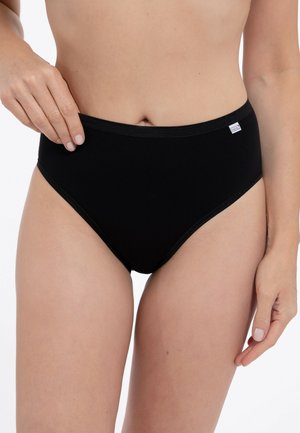 Donna che indossa biancheria intima nera in cotone a vita alta, mano che regola la fascia in vita, sezione centrale del corpo e parte superiore delle cosce visibili.