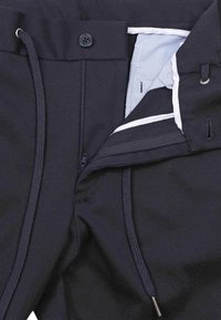 Navy broek van zachte stof, met een knoopsluiting, rits en trekkoord. Aan de binnenkant onthult een gestreepte voering met contrasterende accenten.