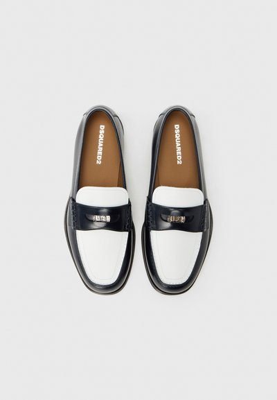 Zwart-witte leren loafers met een gladde textuur, zilveren metalen accenten en een bruine binnenvoering. Klassieke vorm met gedetailleerde stiksels.