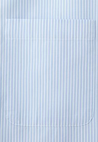 Blåt og hvidt stof med lodrette striber og en syet rektangulær lomme placeret midt i billedet.