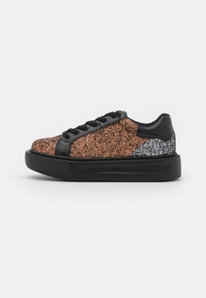Sneaker à plateforme basse avec semelle noire, lacets noirs, dessus pailleté cuivre et patch talon pailleté argenté sur fond blanc.