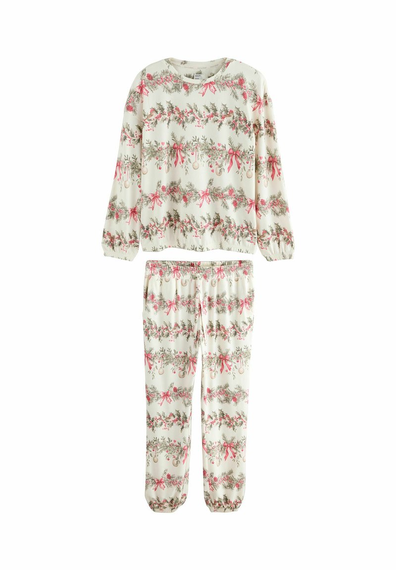 Ensemble de pyjama deux pièces en crème, avec des motifs floraux et des rubans en rose et vert. Manches longues et taille élastique sur le pantalon.