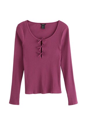 Ribbad långärmad topp i mauve med rundad halsringning och tre dekorativa knytrosetter längs mitten fram.
