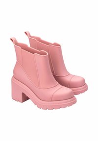 Stivaletti alla caviglia in gomma rosa con suola spessa, pannelli laterali rigati e linguette di trazione. Presentano una texture liscia e un design della punta arrotondata.