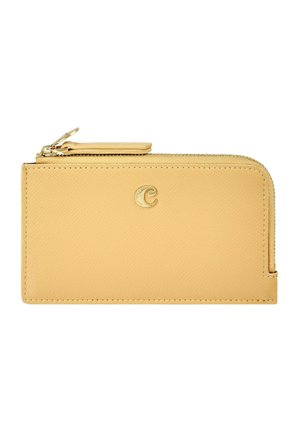 Beżowy portfel skórzany zapinany na zamek z złotym suwakiem oraz małym złotym emblematem litery "C" na przedniej stronie.