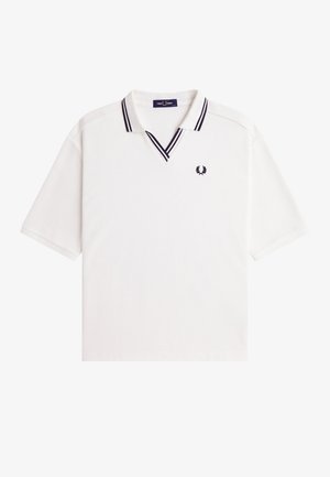 Polo blanc à manches courtes avec double rayure noire sur le col et logo laurier Fred Perry sur le côté gauche de la poitrine.