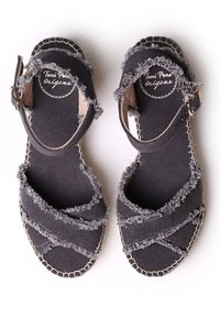 Zwarte canvas espadrille sandalen met rafelige randen, kruisbanden, verstelbare enkelband en gevlochten jute zool. Merklogo op de binnenzool.