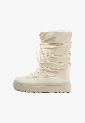 Krém színű hócipők párnázott felső résszel, keresztben fűzött zsinórral és vastag, mintás talppal a tapadás érdekében. Karcsú, lekerekített orr kialakítással rendelkezik.