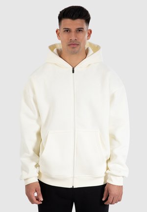Witte hoodie met ritssluiting, gemaakt van zacht materiaal. Voorzien van een capuchon met trekkoord en zijzakken. Ribgebreide manchetten en zoom verhogen het comfort.