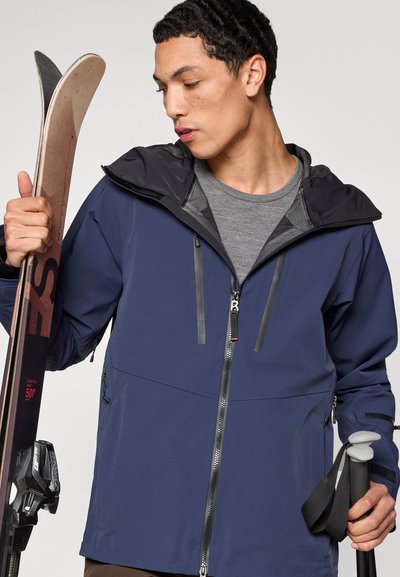 Marineblaue wasserdichte Jacke mit schwarzer Kapuze, Frontreißverschluss und dezenten reflektierenden Akzenten, ausgestattet mit Reißverschlusstaschen an den Seiten.