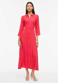 Robe à manches longues, boutonnée, de couleur rose vif avec des rayures roses foncées alternées, un torse ajusté et une jupe fluide. Texture de tissu lisse.